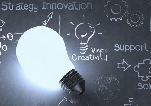 Innovation and creativity lightbulb in front of chalkboard graphic